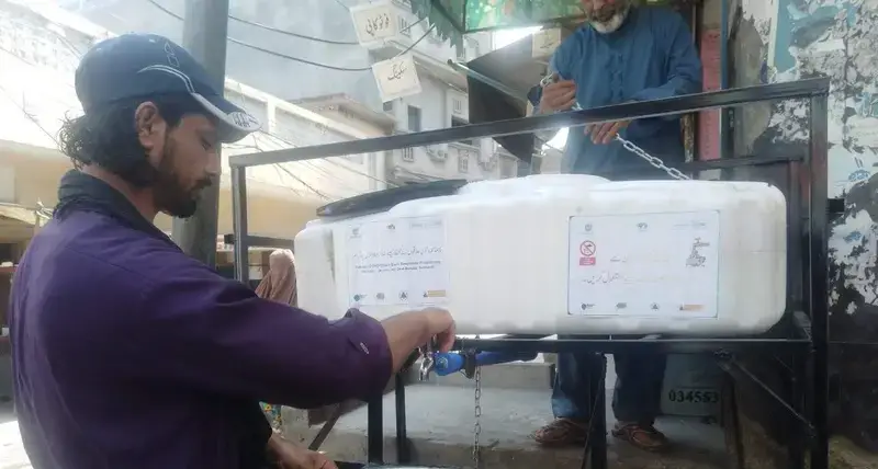 A shopkeeper washes his hands at facility provided by UN-Habitat as part of efforts to stop the spread of COVID-19 in the Pakistani city of Rawalpindi.
